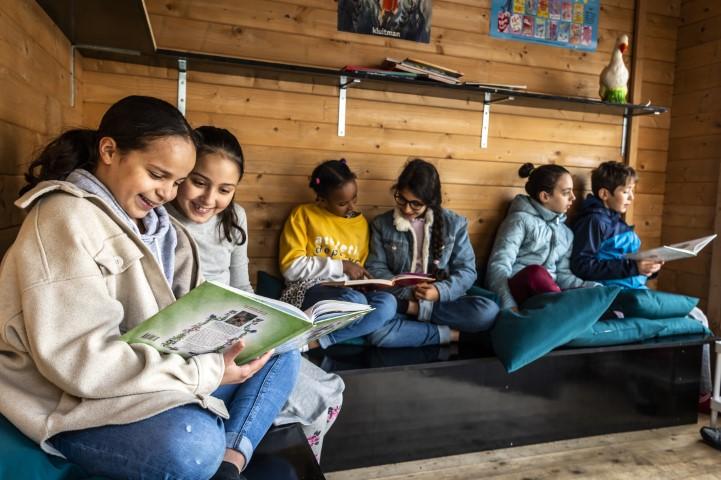 Kinderen lezen boeken in een klas van De Mozaïek.